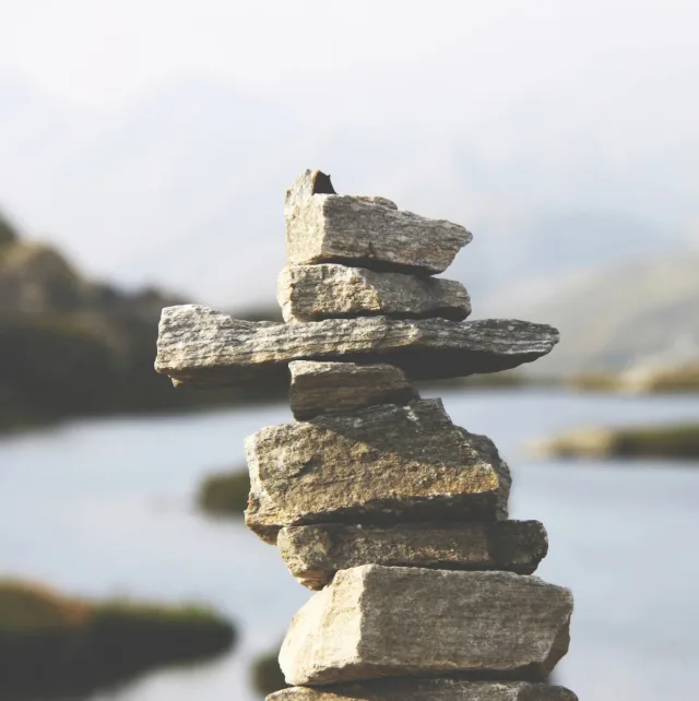 Balanced stone cairn at the edge of a calm lake