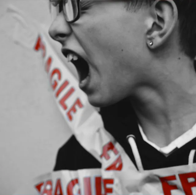 Person shouting, « FRAGILE » tape across the face