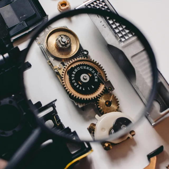 Magnifying glass over the gears of a dismantled mechanism