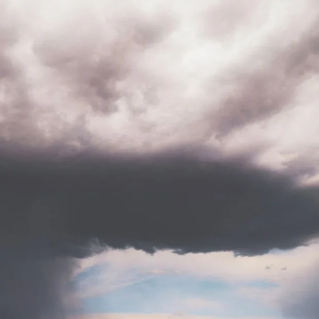 Un gros nuage d'orage sombre au-dessus d'un coin de ciel bleu